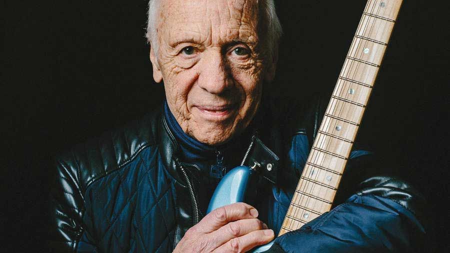 Robin Trower cradling a guitar (studio portrait)