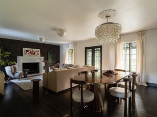 Living room with dark flooring, dining table and wallpaper.