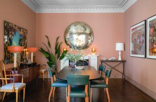 pink dining room with green chairs and candles