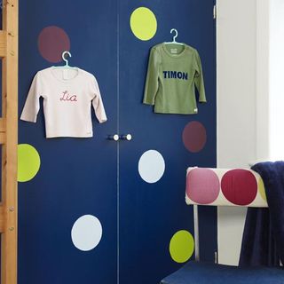child bedroom with dark blue wardrobe and colourful circles on doors