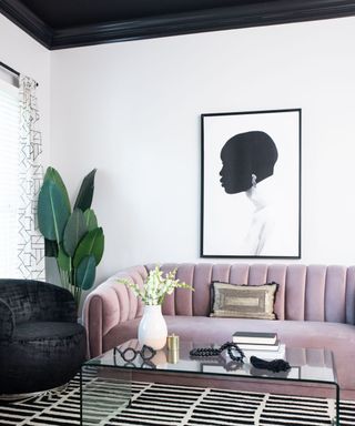 A white living room with a pink velvet couch