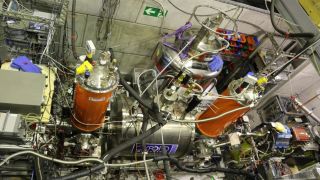 A series of chambers and wires holding together a system that contains antimatter qubits