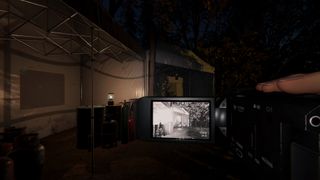 From a first-person POV, the player looks at a tent in the darkness using the night vision of their video camera