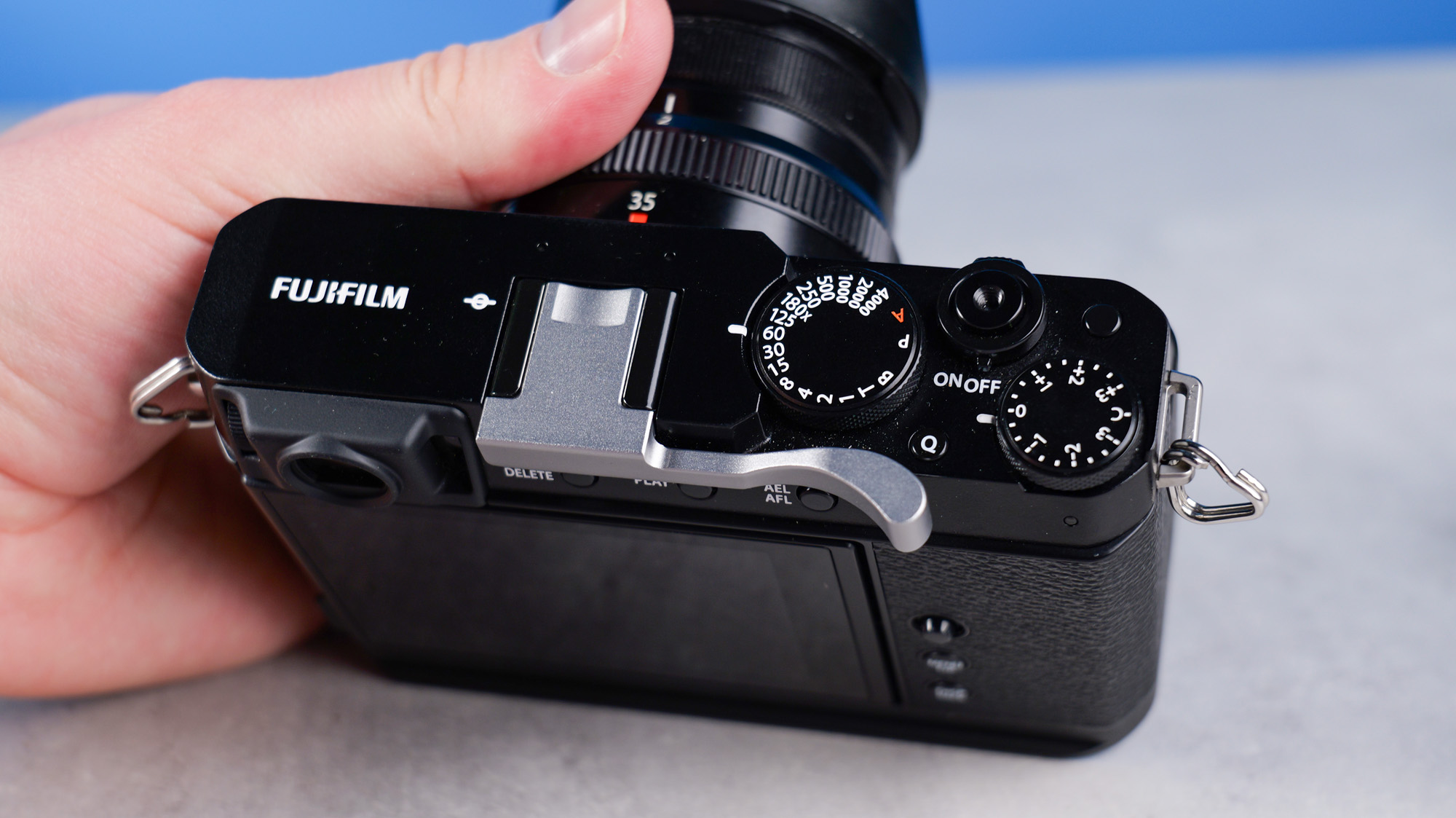 Fujifilm X-E4 on a stone surface and blue background