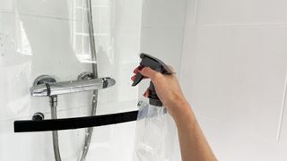 Glass cleaning product being applied to a glass shower door