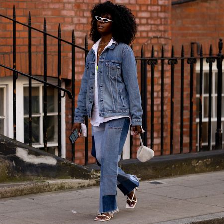 London spring fashion week attendee wearing a jean jacket and jeans and white button down shirt 