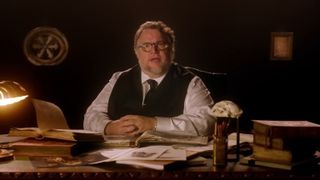 Cabinet of Curiosities cast: Guillermo Del Toro sitting behind a desk
