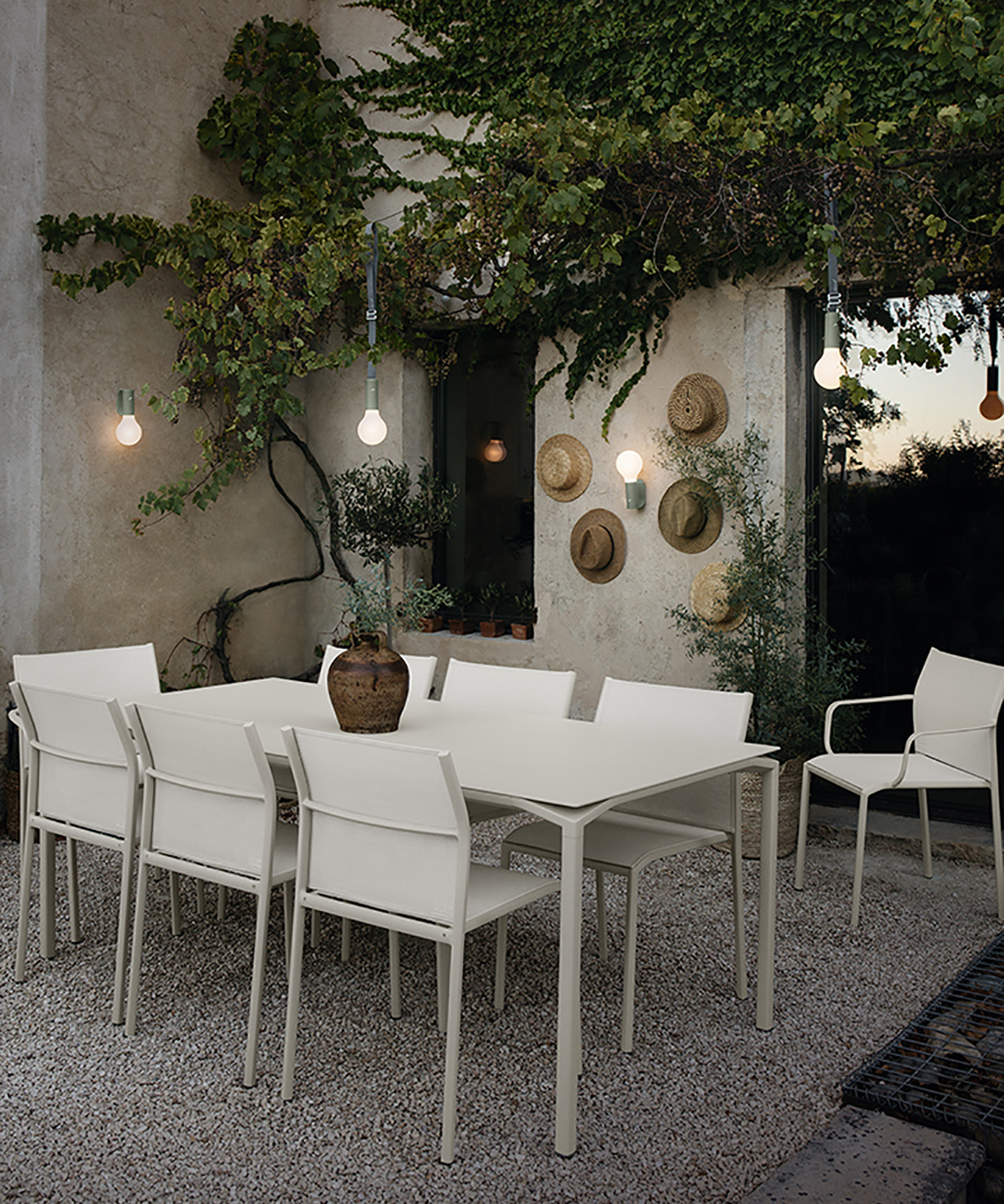 Straw hats attached to a garden wall with lights