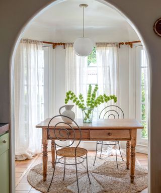 breakfast or coffee table nook with a small archway and french doors and a bistro table and iron chairs