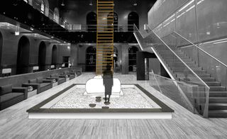 A visualisation of a large lobby area with chairs on the left, a stairwell to the right and a centre pool in the middle with a drawing of a person and a bed.
