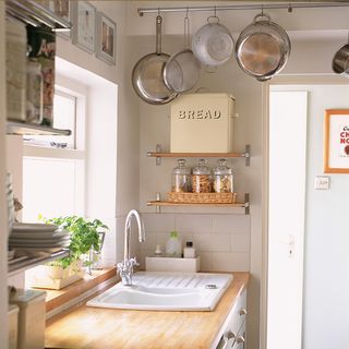 kitchen area with wooden worktop and white wall and glass jar