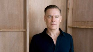 Bryan Adams pictured against a wooden background