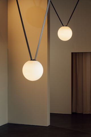Two spherical lamps hanging from textile ropes