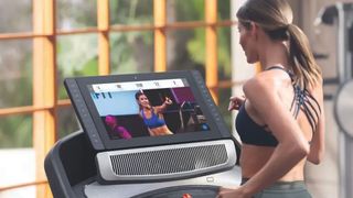 Image shows a woman on the NordicTrack Commercial 2950 treadmill.