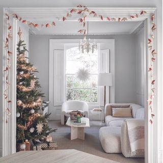 White living room with boucle sofa and christmas tree.