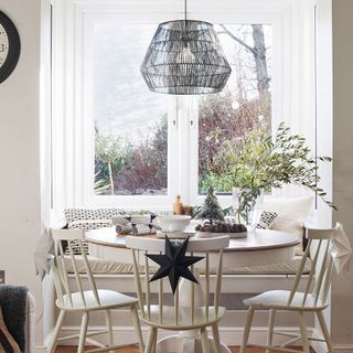 round breakfast table with chairs under rattan lampshade