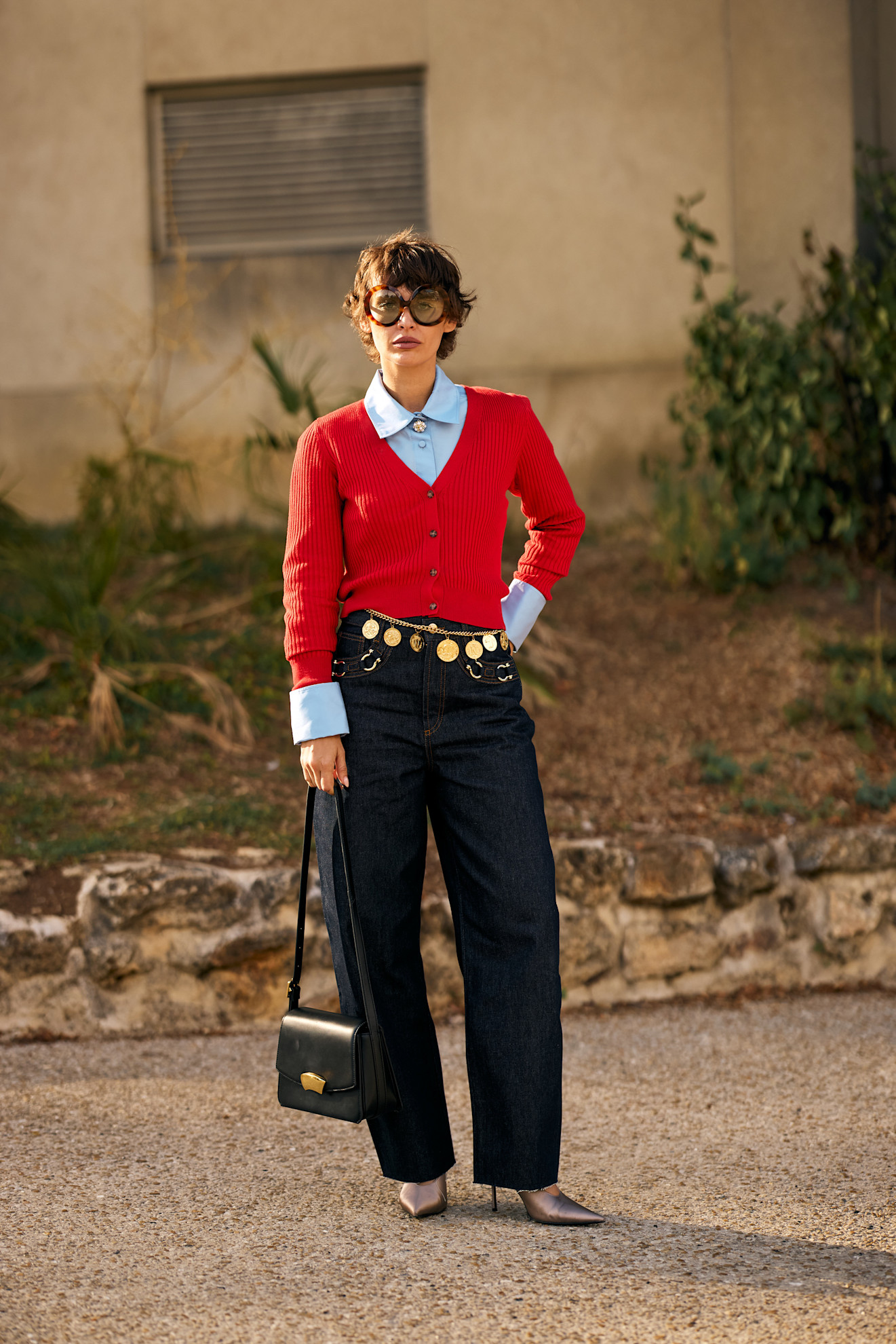 Paris Fashion Week attendee wears blue jeans with a blue shirt and red top.