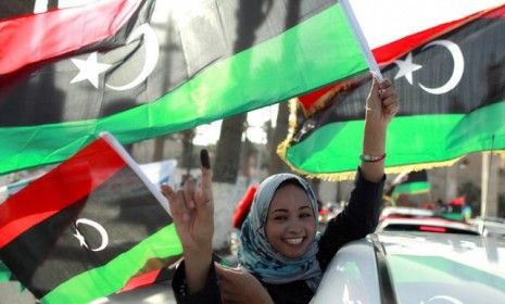 A woman shows off her inked finger and celebrates casting her vote during Libya&amp;#039;s first election since the end of Moammar Gadhafi&amp;#039;s 42-year reign last year.