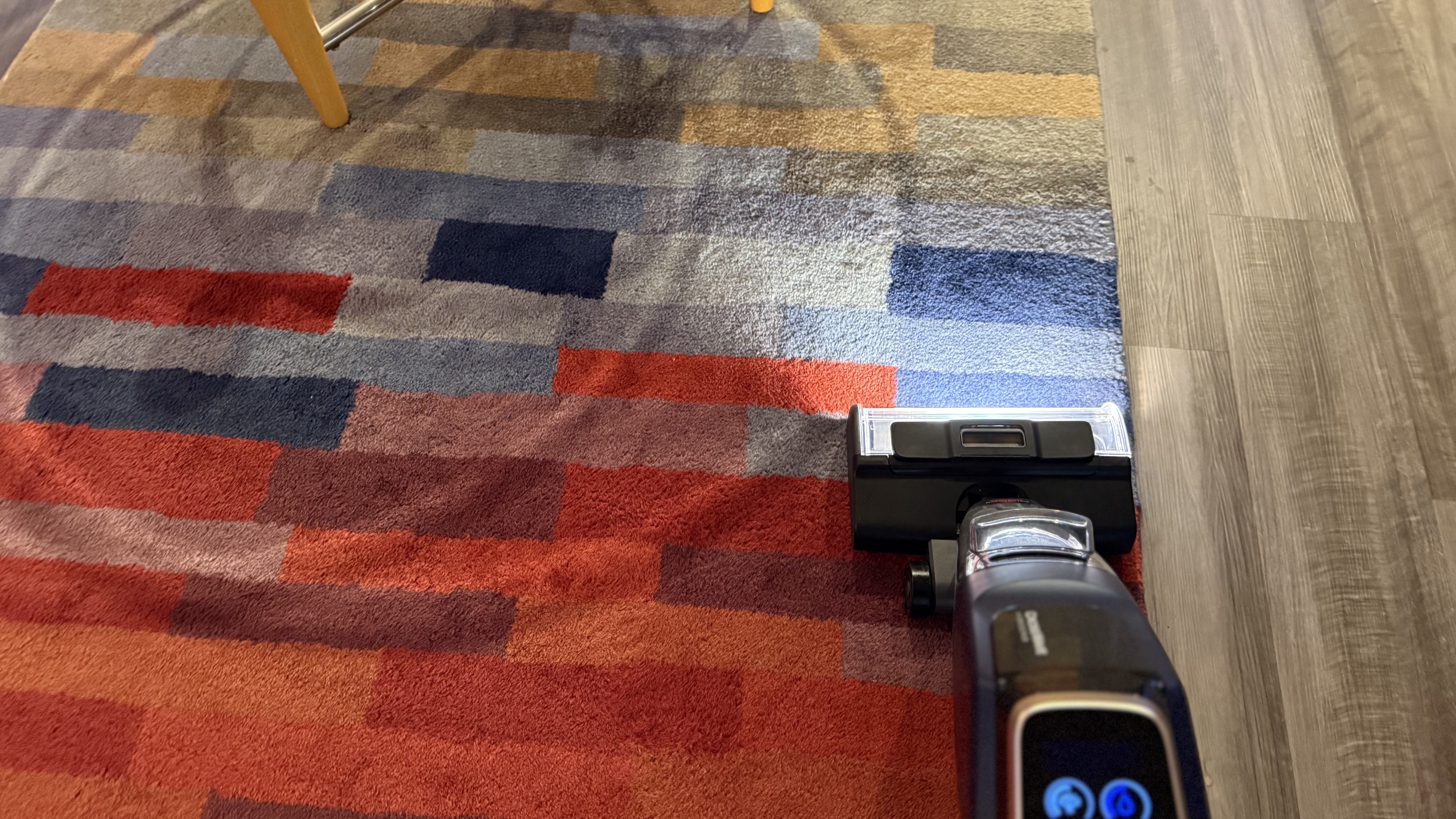 Bissell CrossWave HydroScrub All-in-One-Multi-Surface Cleaner with light illuminated being used to clean area rug