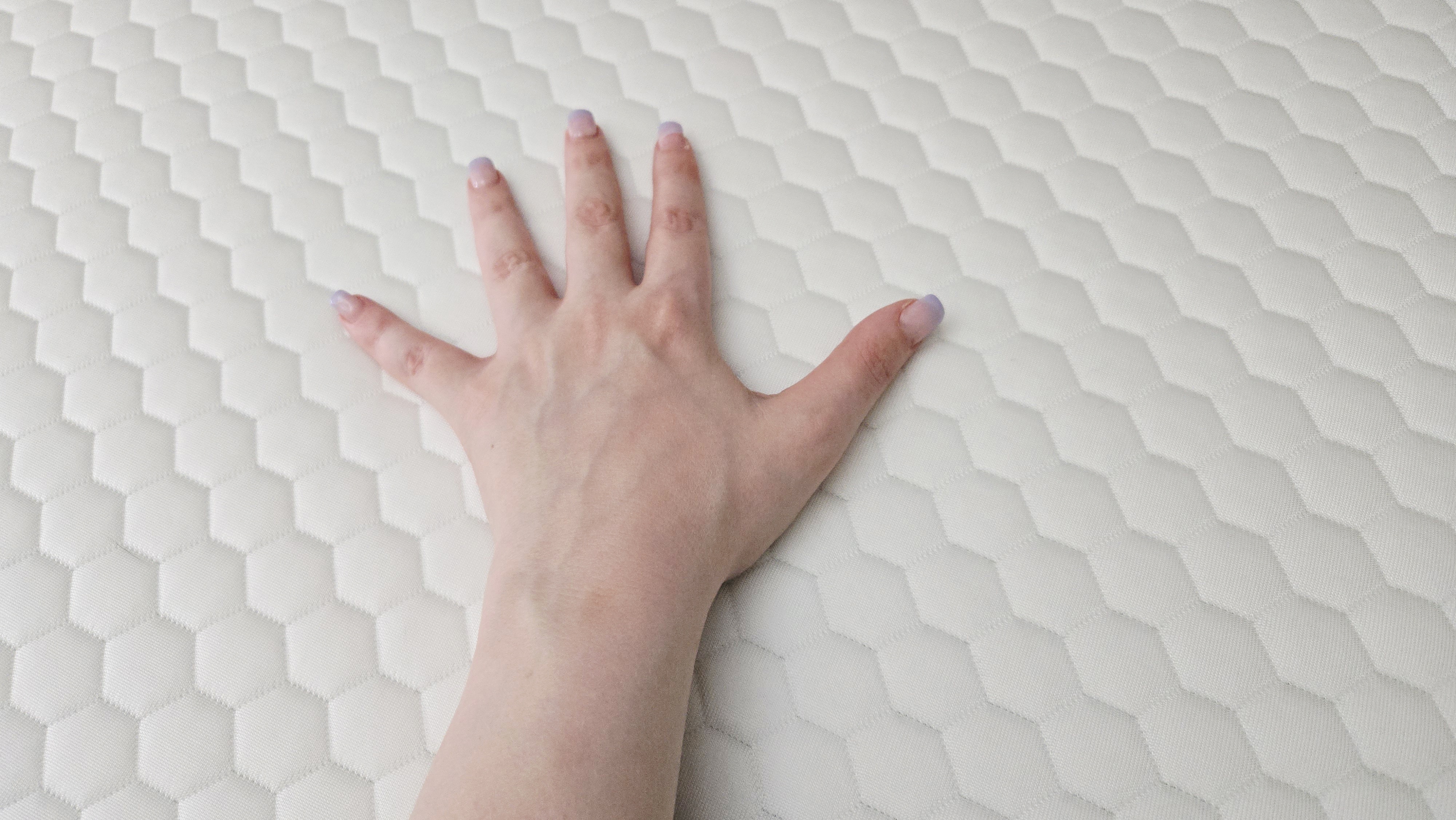 Helix ErgoAlign Mattress Topper with a manicured hand on top of its GlacioTex cover
