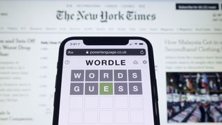 Wordle on phone with the New York Times website in the background 