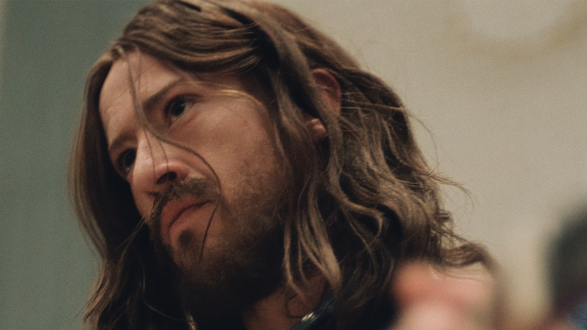 A Close up of Joseph Quinn tilting his head as George Harrison
