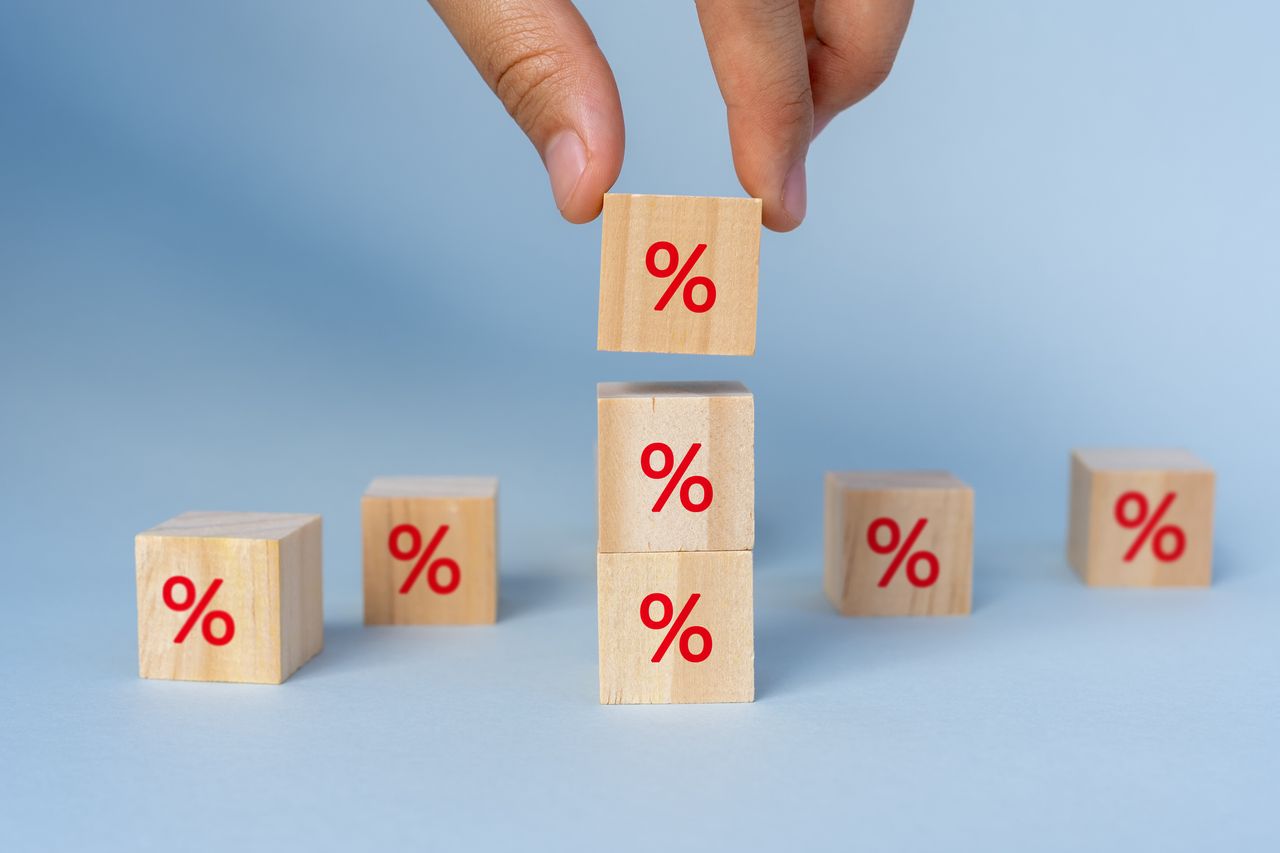 Hands Stacking Percentage Signs on Wood Toy Block