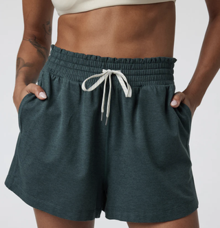 a model wears a pair of vuori shorts in front of a plain backdrop