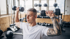 Man performing dumbbell shoulder press