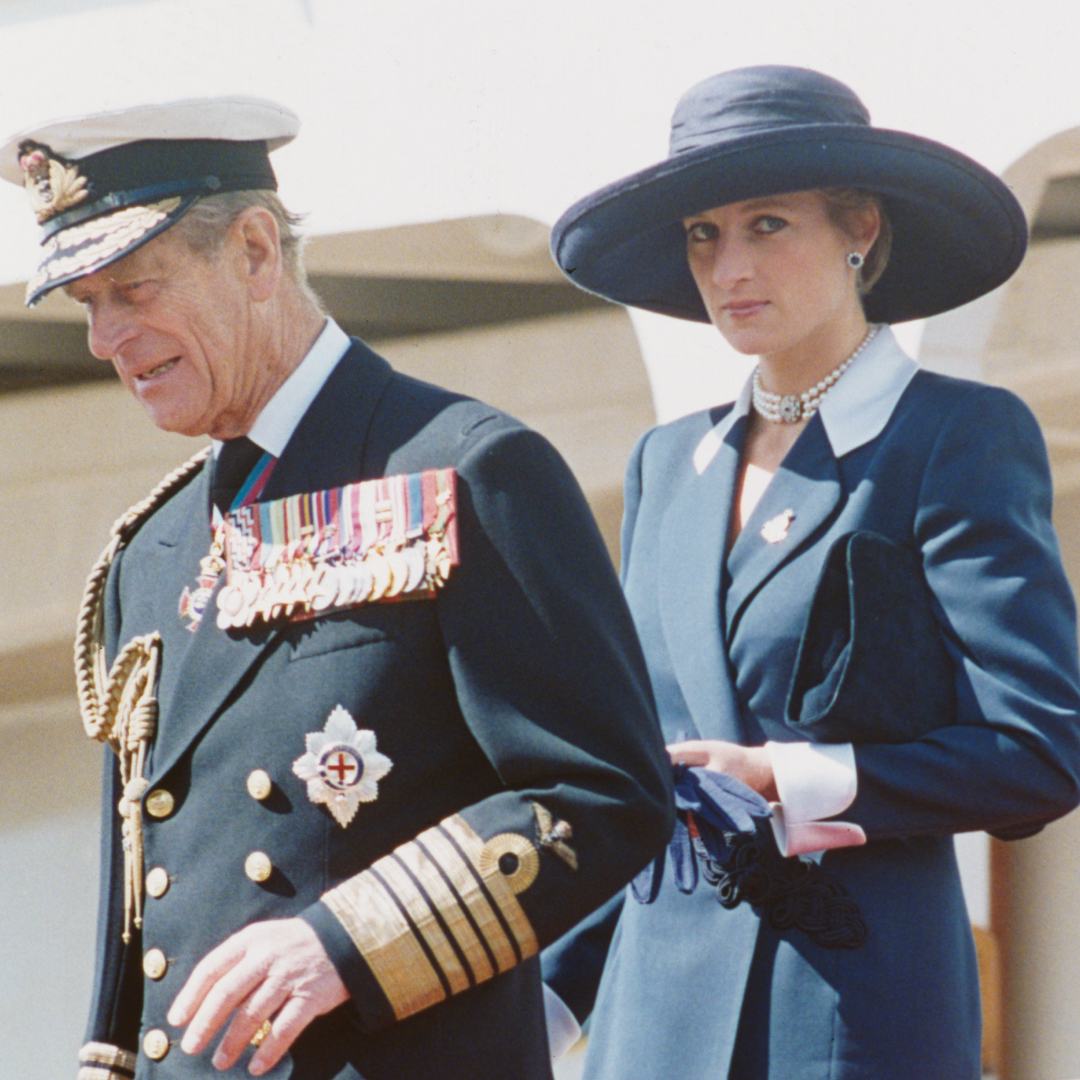 Prince Philip wears military uniform and Princess Diana wears a navy coat dress with a large-brim hat