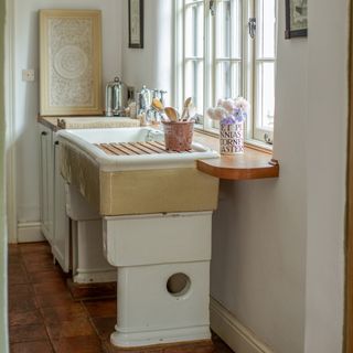 salvaged sink under a window in a farmhouse kitchen