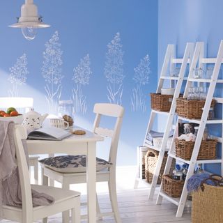 dining room with blue walls with white mural, with white dining table and chairs
