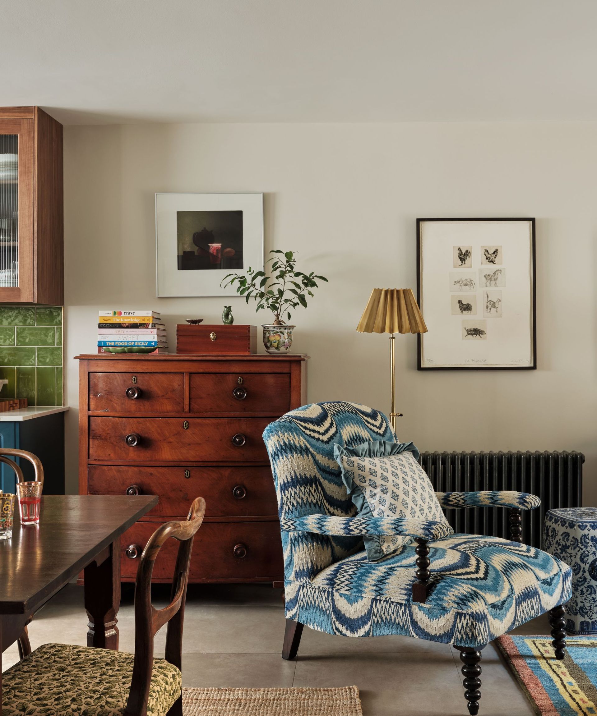 Vintage living room with wood dresser, upholstered armchair and colourful rug