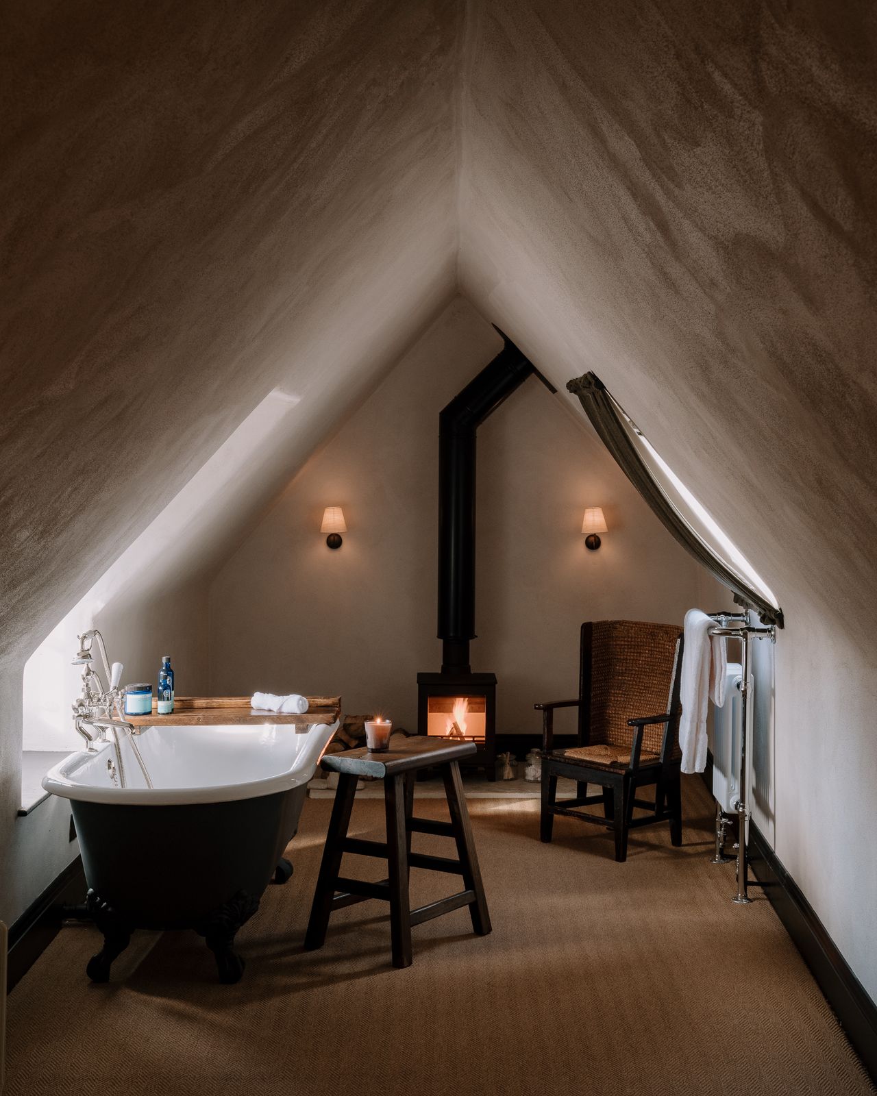 A modern rustic bedroom features a wide bath and a wood smoke stove.