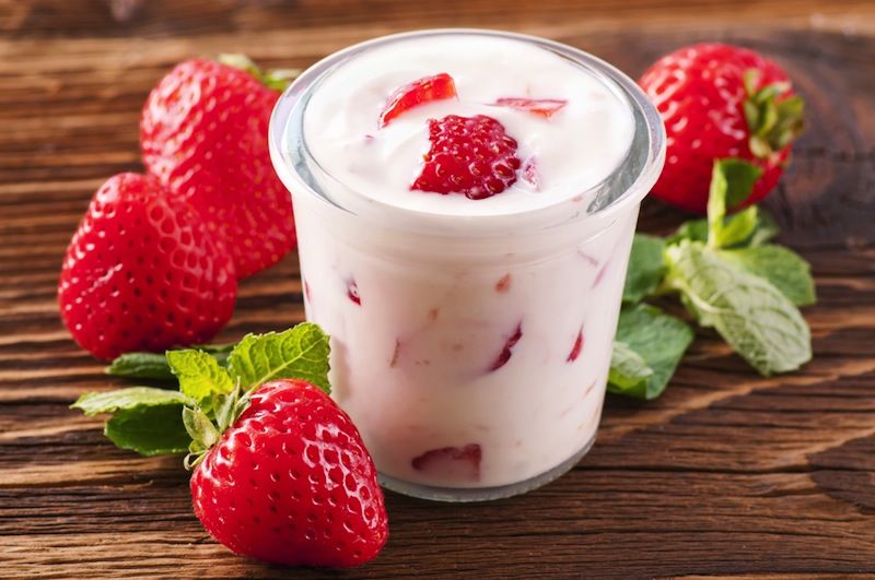 A cup of yogurt with berries in it