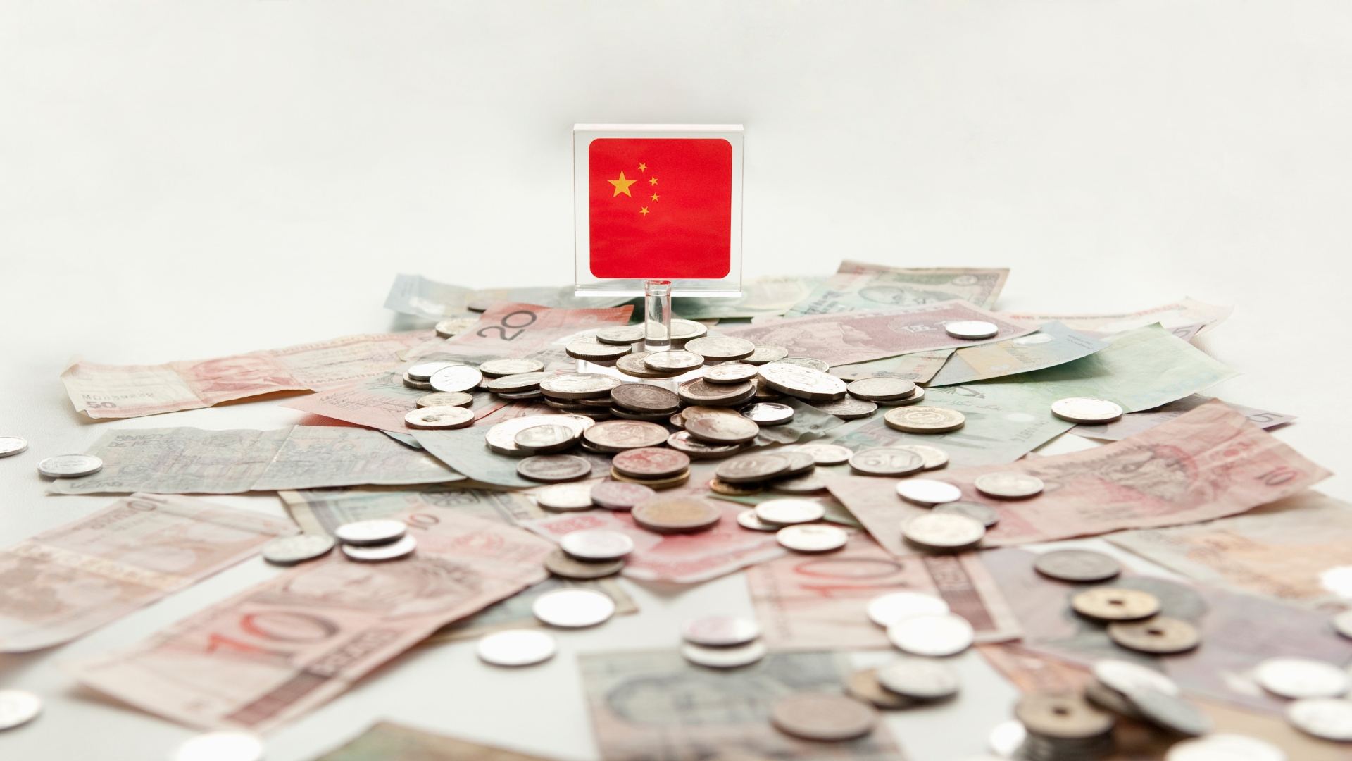 Chinese flag on top of some paper money and coins