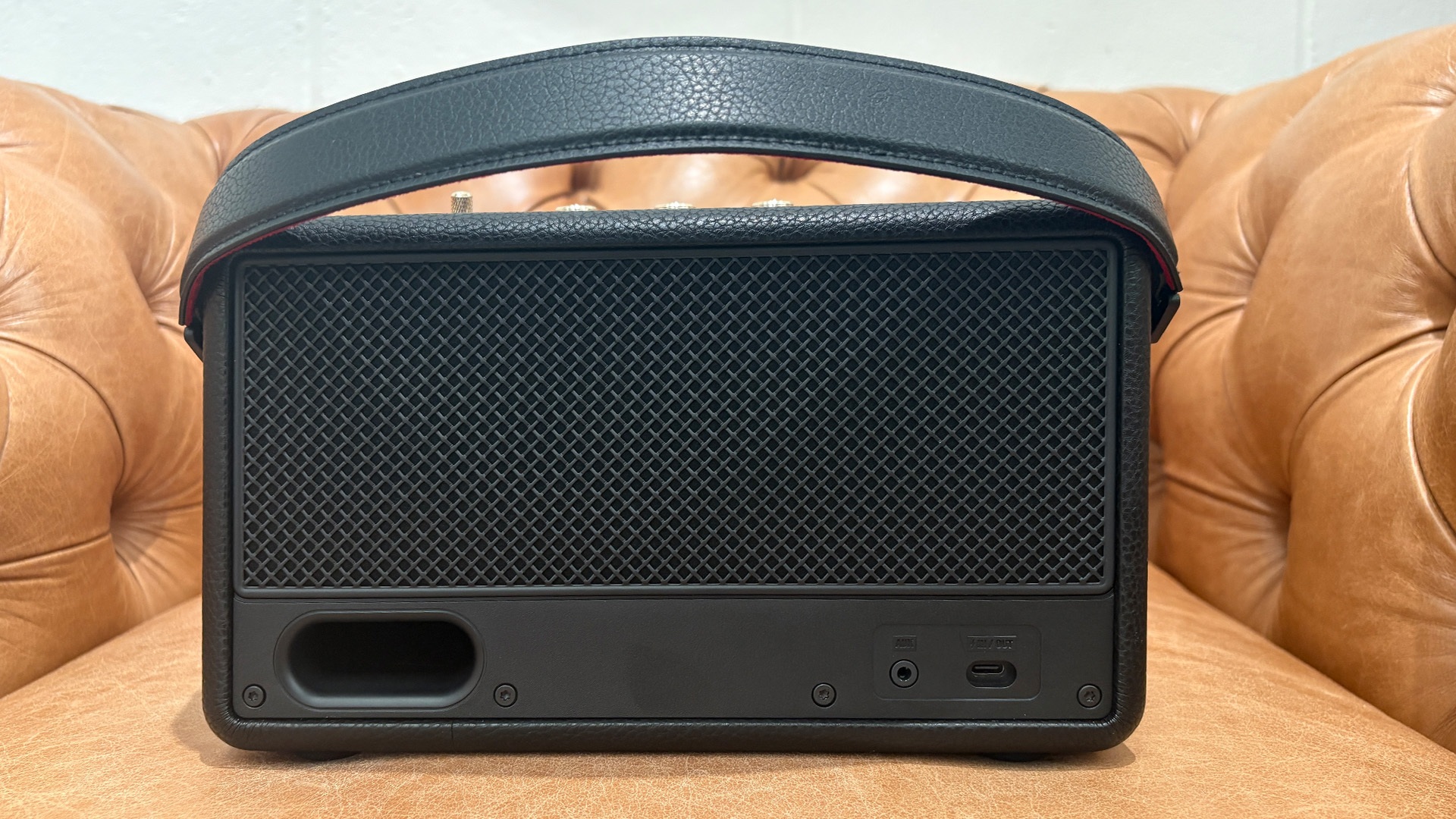Marshall Kilburn III wireless speaker on light brown leather armchair, rear of unit showing connections