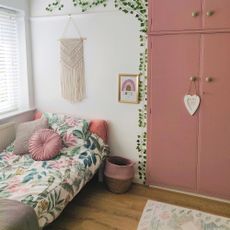 Garden themed kids bedroom with white walls and pink cupboards