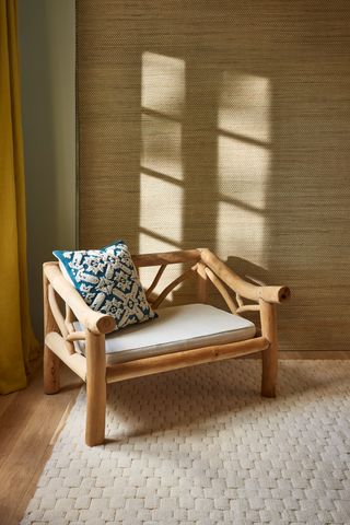 Wooden oversized accent chair in a neutral living room corner setting