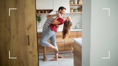 Man and woman dancing in the kitchen, laughing and smiling, representing the ballet dancer sex position