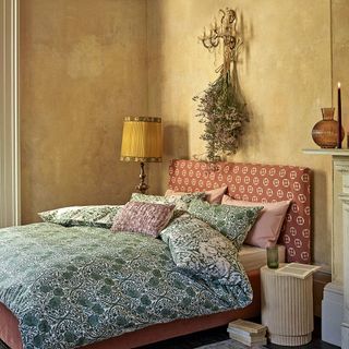 Red headboard with green bedding and yellow walls