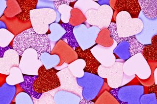 Heart confetti in pink, purple and red, with sparkles.