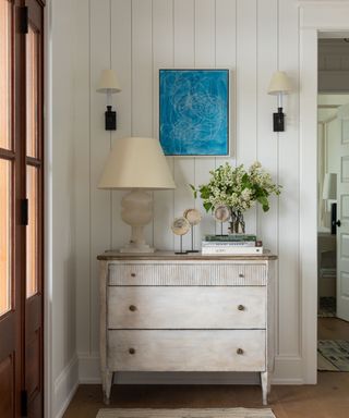 coastal entryway with white dresser and blue artwork