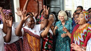 Queen Camilla dances with volunteers and staff from Sauti Ya Wanawake