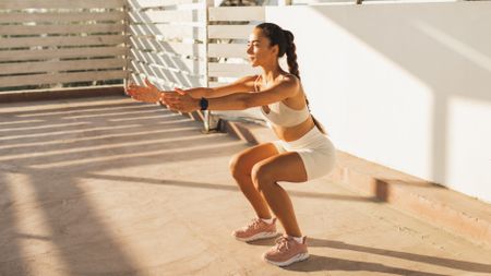 a photo of a woman doing a bodyweight squat