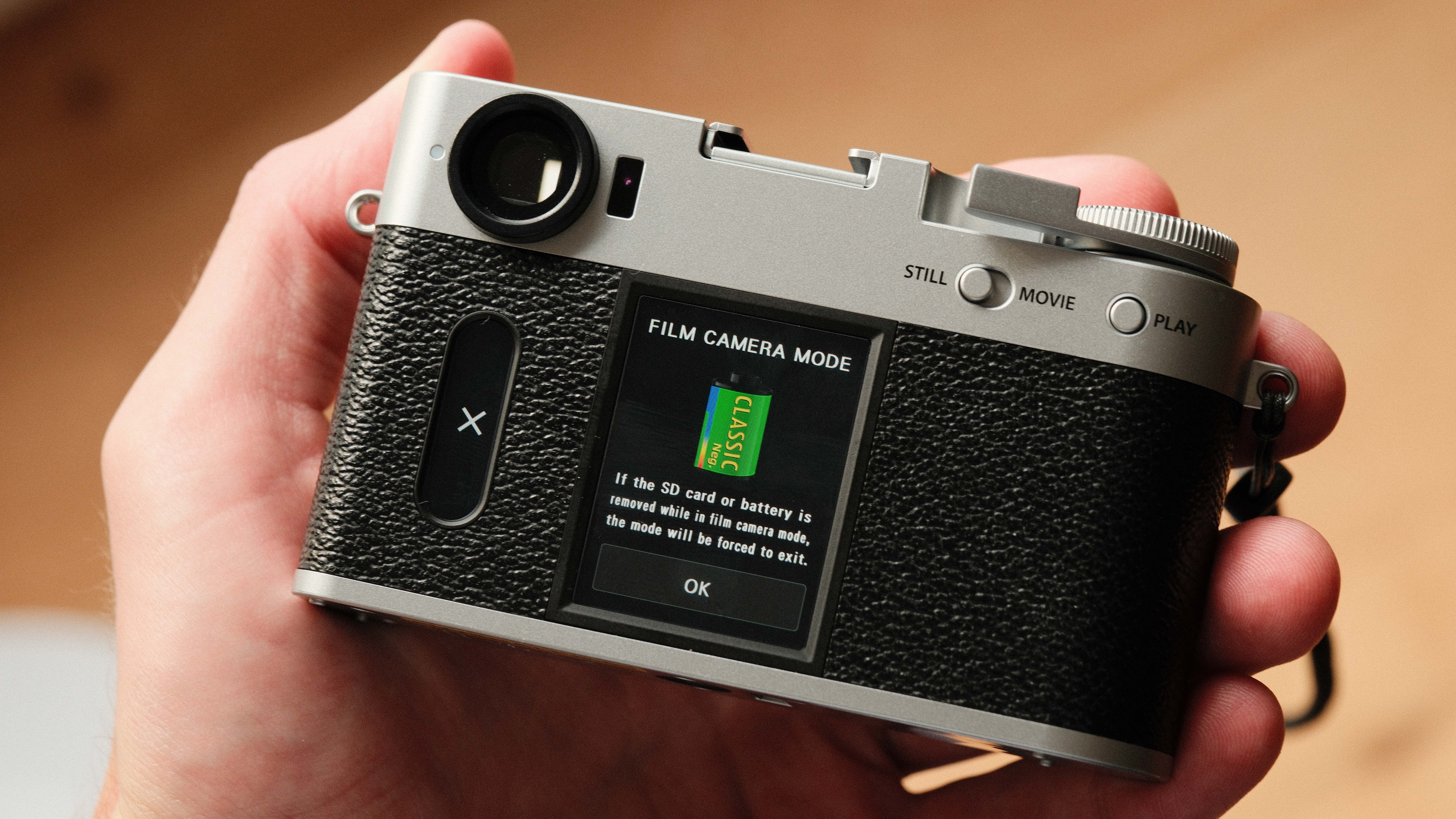 Fujifilm X Half camera held in a hand showing the film camera mode
