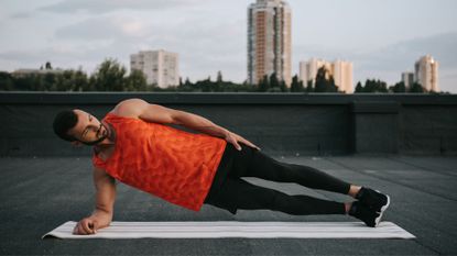 A man performing a side plank as part of an ab workout