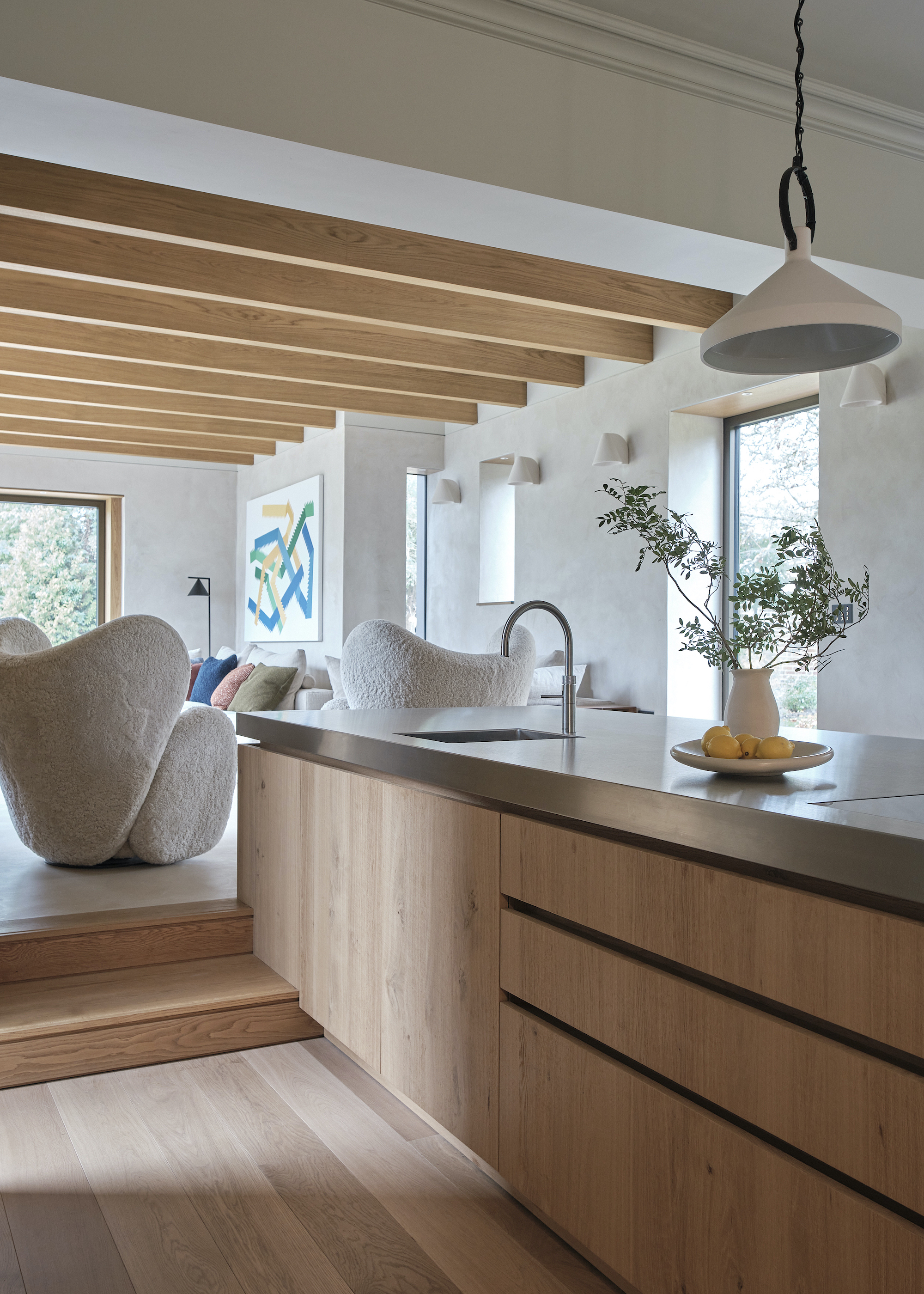 Wood flooring in a kitchen extension. The cabinets on the kitchen island are also wood in an open concept living space.