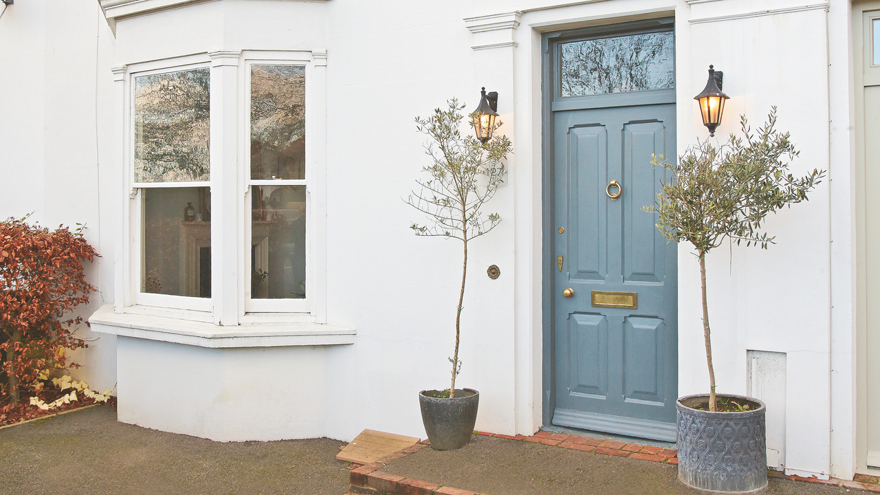 Exterior of Victorian house, architectural features, bay trees, wall lights, sash windows.