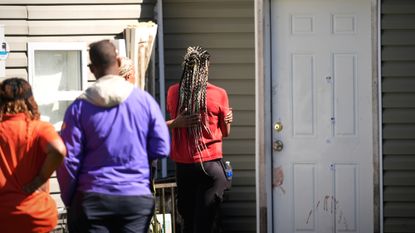 Mourners gather outside stained door at Shreveport, Louisiana, scene of mass killing